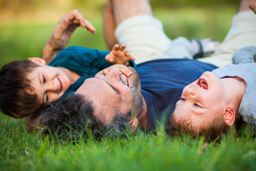 Dad and boys playing in the grass
